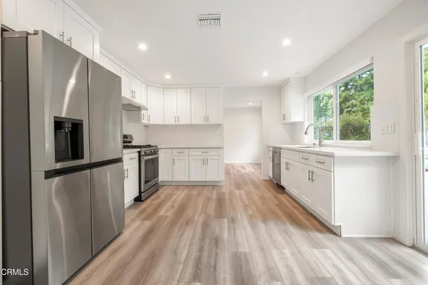 a kitchen with white cabinets and stainless steel appliances