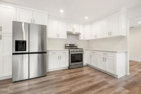 a kitchen with white cabinets and stainless steel appliances