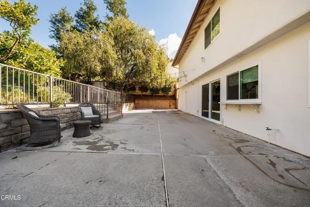 a view of a patio with table and chairs and wooden fence