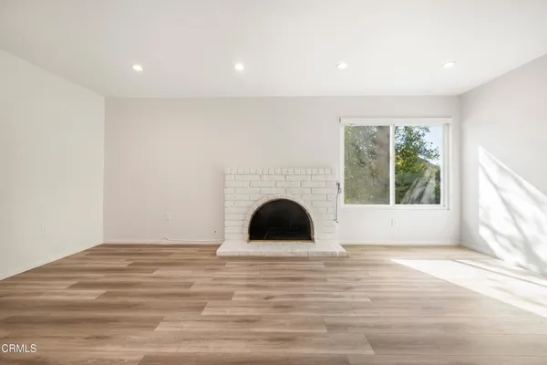 a view of a room with wooden floor and fireplace