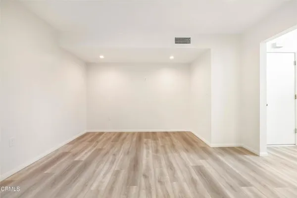 a view of a room with wooden floor and white walls