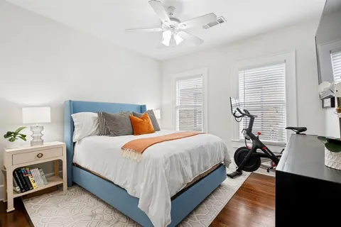 a bedroom with bed a chandelier and a window