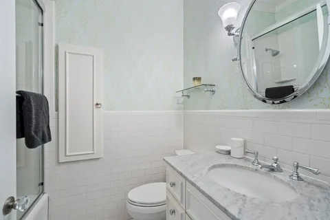 a bathroom with a granite countertop sink toilet and shower