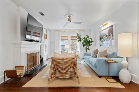 a living room with furniture a flat screen tv and a fireplace