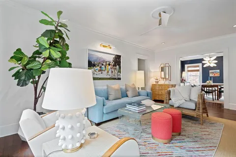 a living room with furniture flowerpot and wooden floor