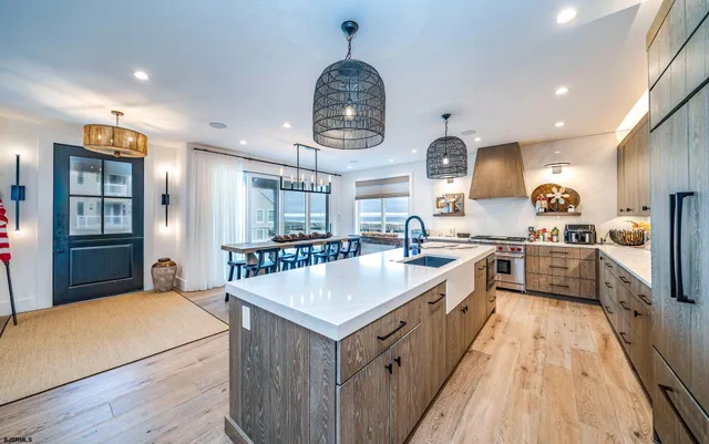 a large kitchen with kitchen island a stove a sink a refrigerator and a wooden floors