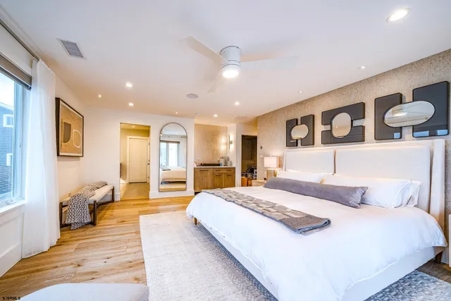 a spacious bedroom with a bed and wooden floor