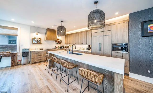 a kitchen with stainless steel appliances a dining table chairs stove and sink