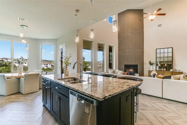 a kitchen with granite countertop a sink and white cabinets