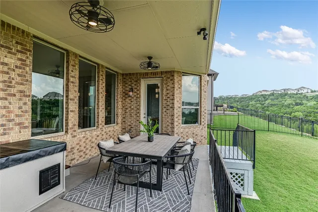 a view of a balcony with furniture and a yard