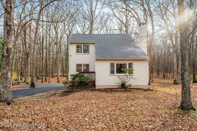 a view of a house with backyard and trees