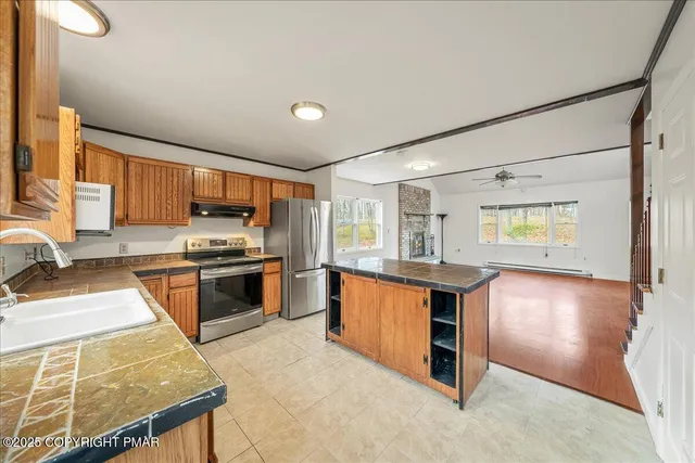 a kitchen with stainless steel appliances granite countertop a stove a sink and a microwave