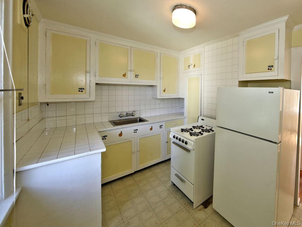 56 South Lawn Avenue, Unit 3 Elmsford, NY 10523 - Photo 2 of 7 a kitchen with a refrigerator and a stove