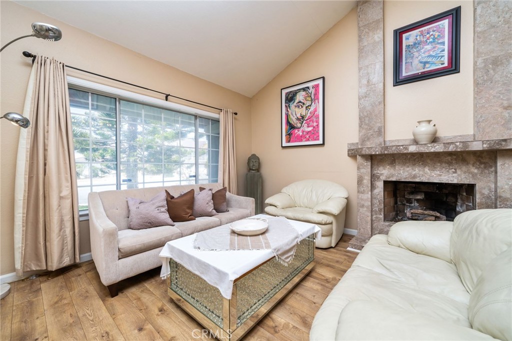 23472 Stirrup Drive Diamond Bar, CA 91765 - Photo 2 of 7 a living room with furniture a large window and a fireplace