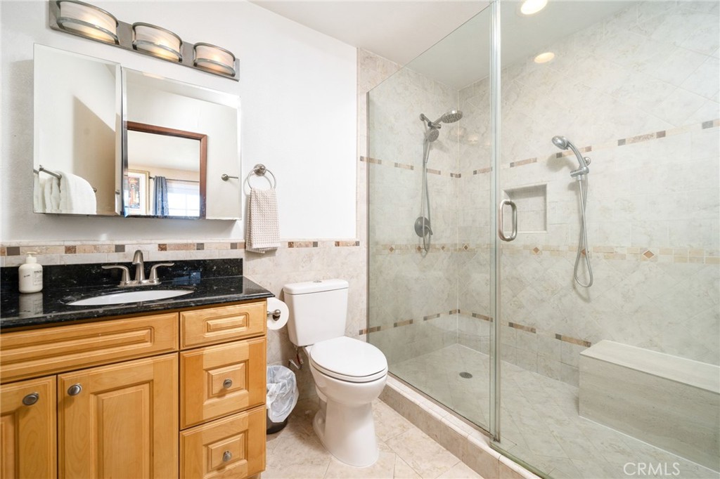 23472 Stirrup Drive Diamond Bar, CA 91765 - Photo 6 of 7 a bathroom with a granite countertop sink a toilet a mirror and shower