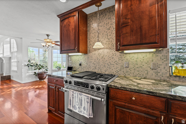 4117 North Wolf Ridge Circle Eden, UT 84310 - Photo 12 of 63 Stainless steel range with a built-in griddle, complemented by a mosaic tile backsplash and rich wood cabinetry