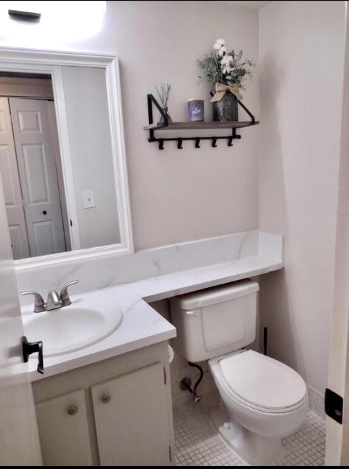 209 Suffolk F, Unit 209 Boca Raton, FL 33434 - Photo 13 of 21 a bathroom with a sink toilet and a mirror