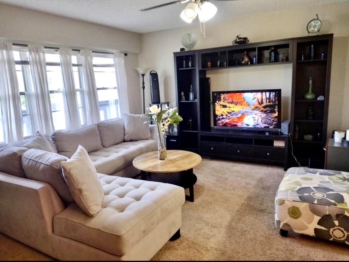 209 Suffolk F, Unit 209 Boca Raton, FL 33434 - Photo 7 of 21 a living room with furniture and a flat screen tv
