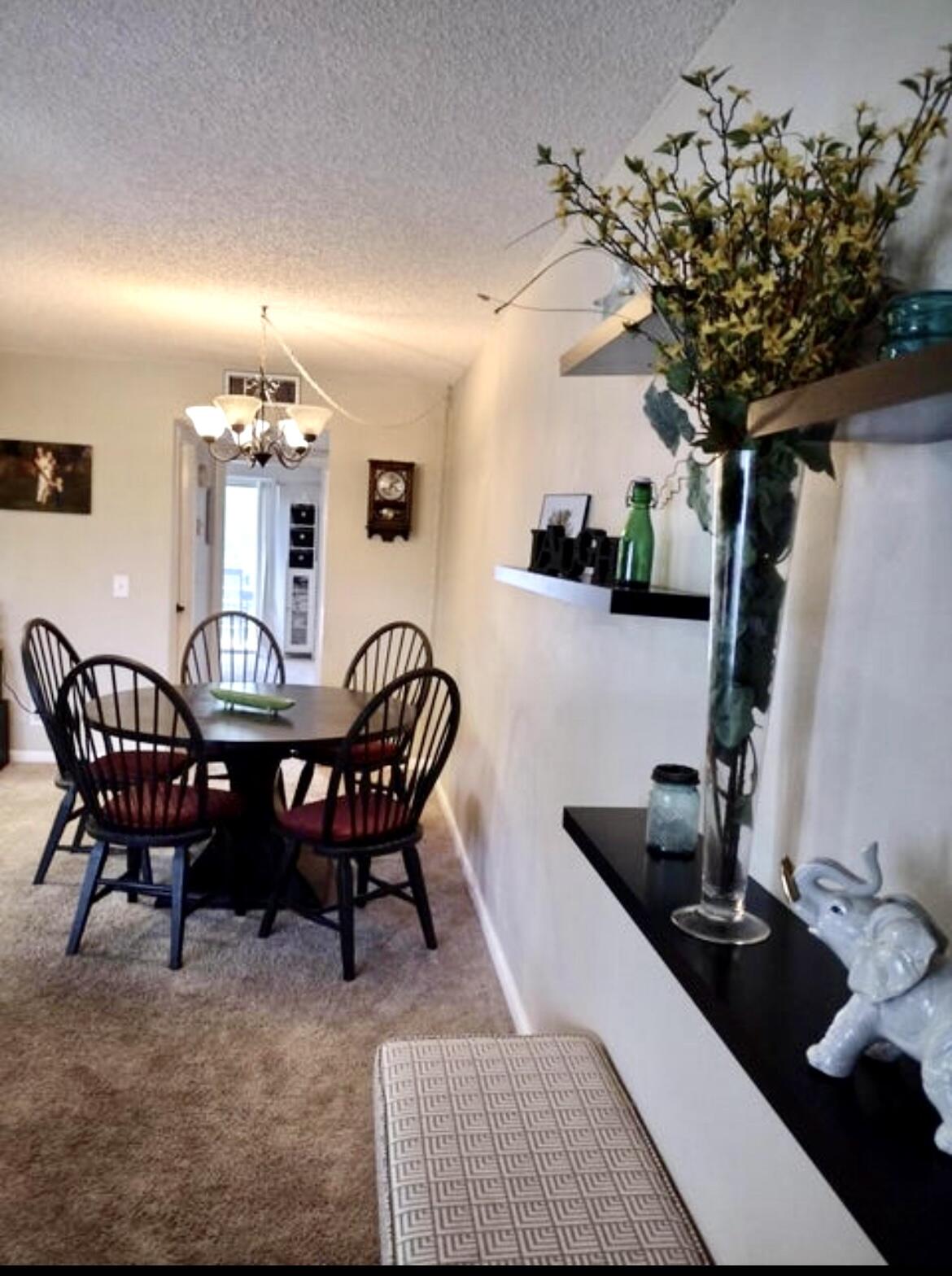 209 Suffolk F, Unit 209 Boca Raton, FL 33434 - Photo 8 of 21 a view of a dining room with furniture and chandelier