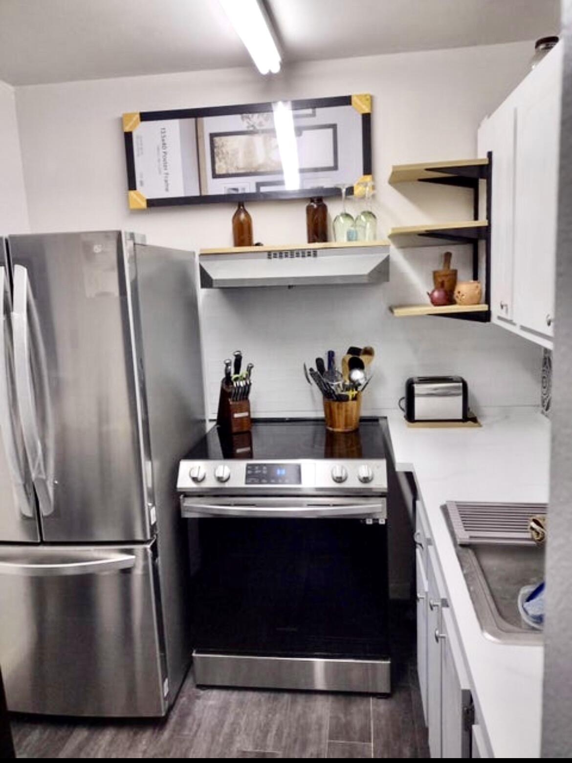 209 Suffolk F, Unit 209 Boca Raton, FL 33434 - Photo 10 of 21 a kitchen with stainless steel appliances granite countertop a refrigerator a stove and wooden cabinets