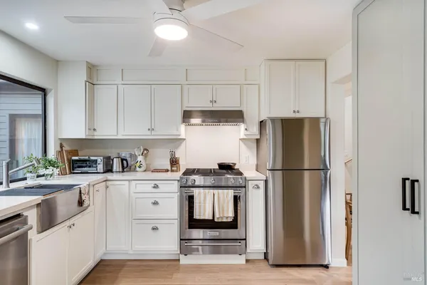a kitchen with white cabinets and white appliances