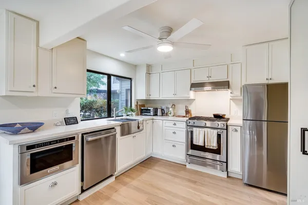 a kitchen with cabinets stainless steel appliances and window