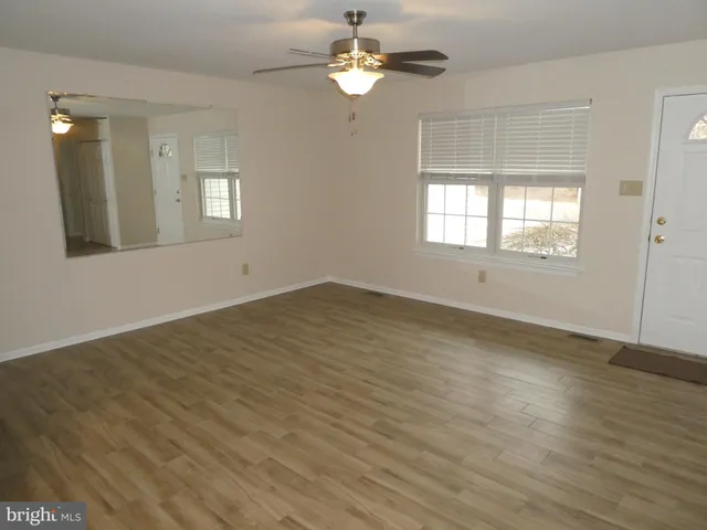 wooden floor in an empty room with a window