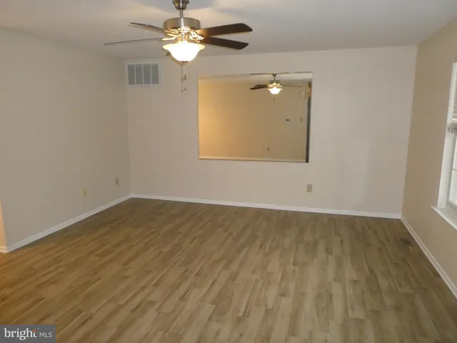 wooden floor in an empty room with a window