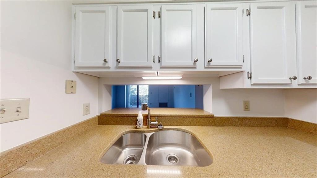 300 Johnson Ferry Road, Unit B409 Atlanta, GA 30328 - Photo 24 of 40 a kitchen with stainless steel appliances granite countertop a sink and a white cabinets