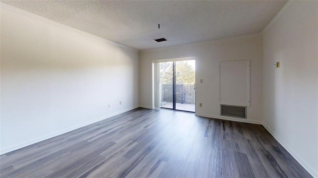 300 Johnson Ferry Road, Unit B409 Atlanta, GA 30328 - Photo 29 of 40 a view of an empty room with wooden floor and a window
