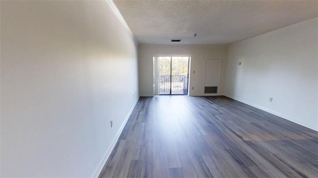 300 Johnson Ferry Road, Unit B409 Atlanta, GA 30328 - Photo 9 of 40 a view of an empty room with wooden floor and a window