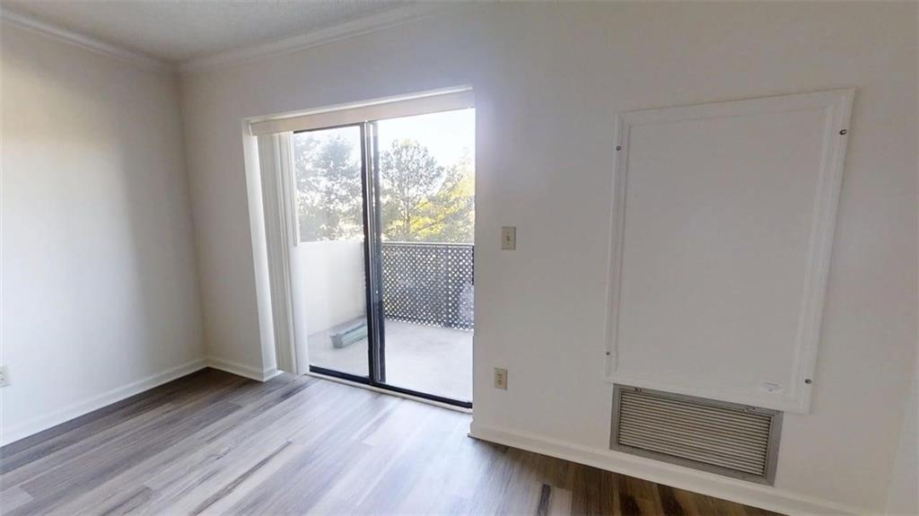 300 Johnson Ferry Road, Unit B409 Atlanta, GA 30328 - Photo 10 of 40 a view of an empty room with wooden floor and a window