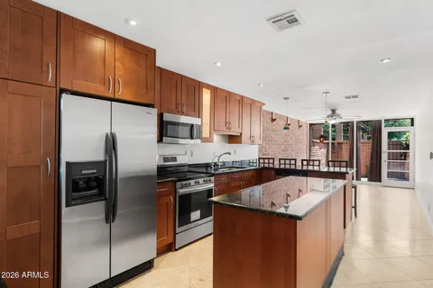 a kitchen with granite countertop a sink stove and refrigerator