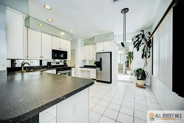 a view of a kitchen with a sink and a refrigerator