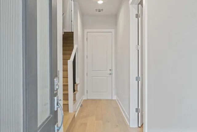 a view of a hallway with wooden floor and entryway