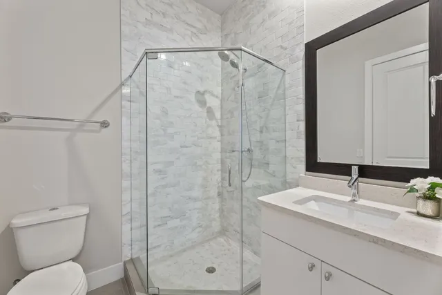 a bathroom with a granite countertop sink toilet and shower