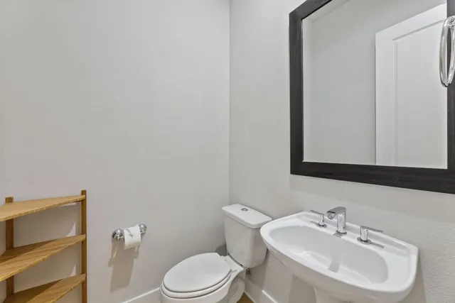 a bathroom with a toilet a sink and mirror