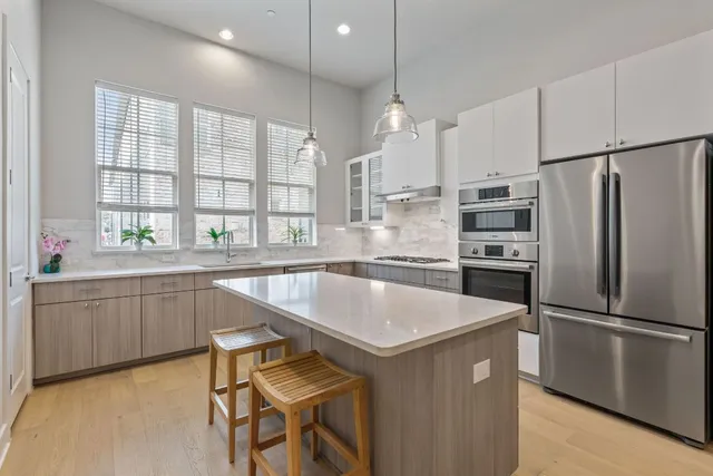 a kitchen with granite countertop a center island stainless steel appliances a sink and a window