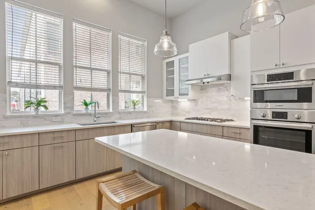 a kitchen with stainless steel appliances a sink a stove and a center island