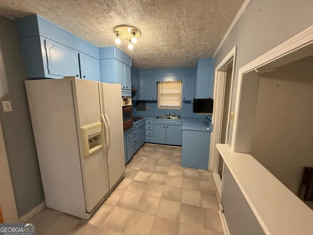 a kitchen with stainless steel appliances a refrigerator and a stove top oven