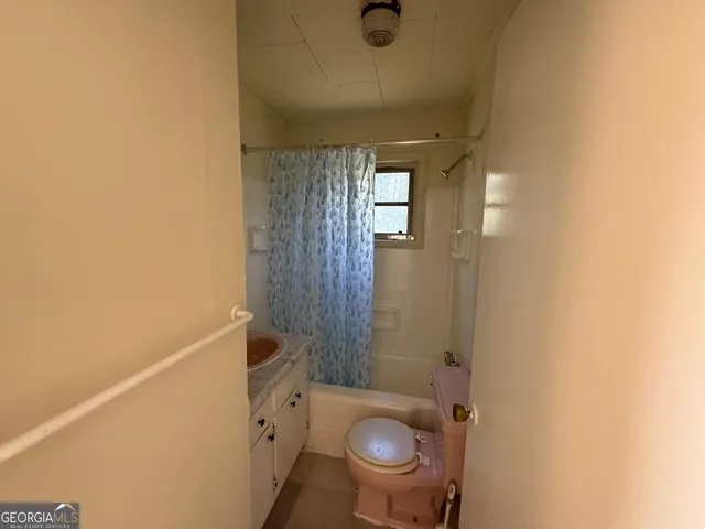 a bathroom with a granite countertop toilet and a sink