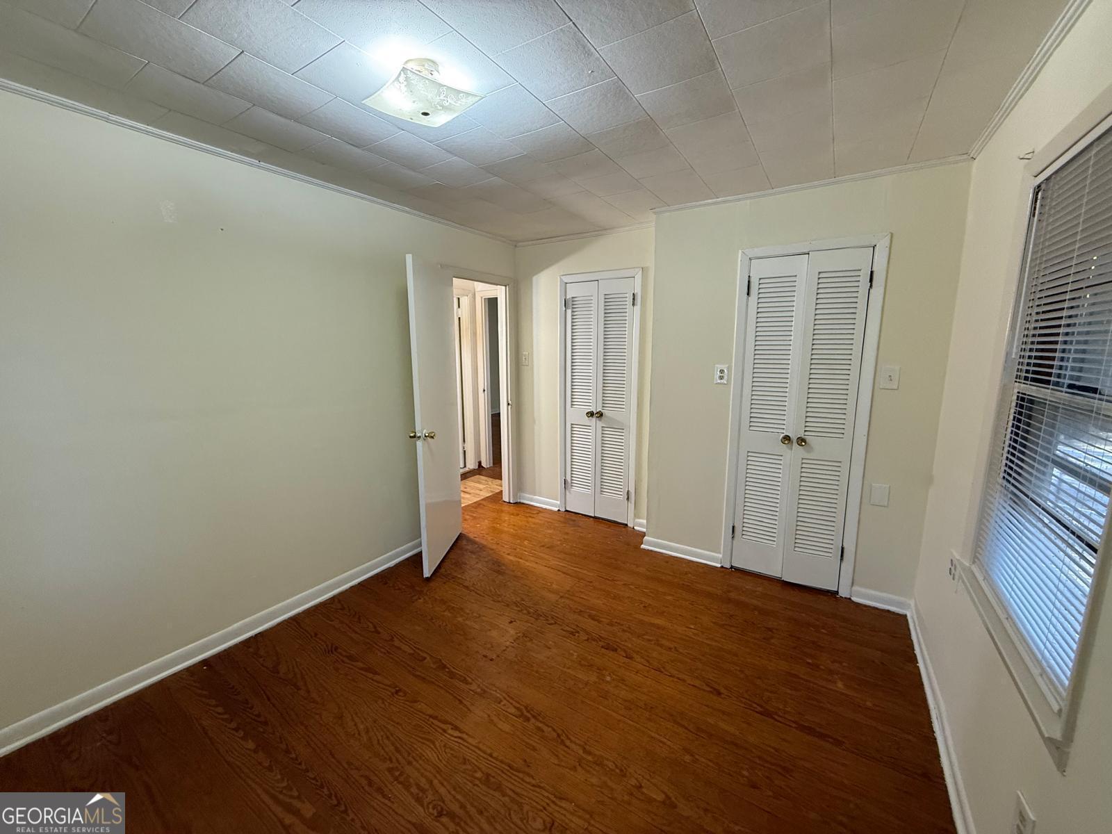 14661 Veterans Memorial Highway Villa Rica, GA 30180 - Photo 9 of 14 an empty room with wooden floor and windows