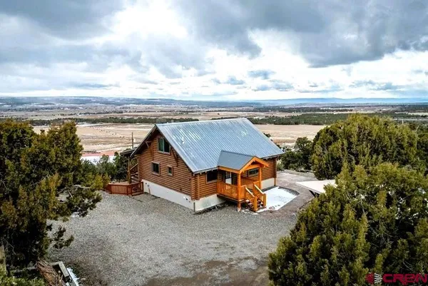an aerial view of a house with a garden and lake view