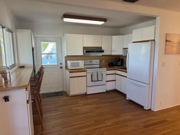 a kitchen with white cabinets and white appliances