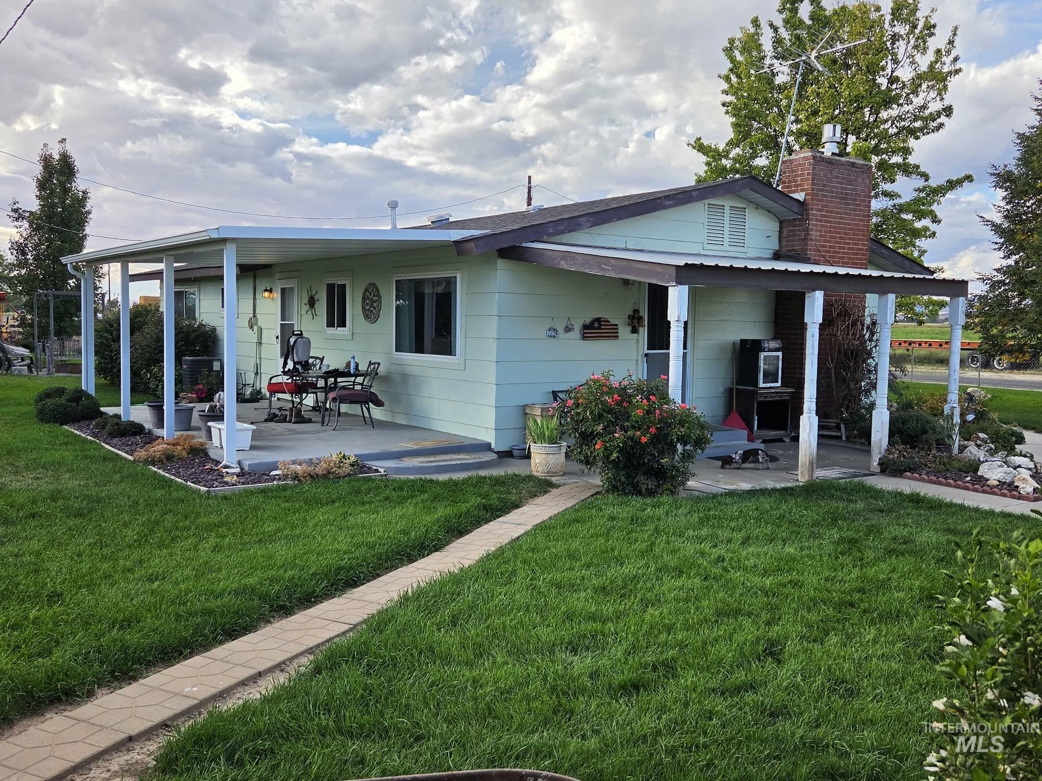 1535 Sunnyside Road Weiser, ID 83672 - Photo 20 of 26 Covered patio area, brick chimney, gabled roof, paved walkway, established landscaping