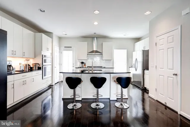 a kitchen with white cabinets and appliances