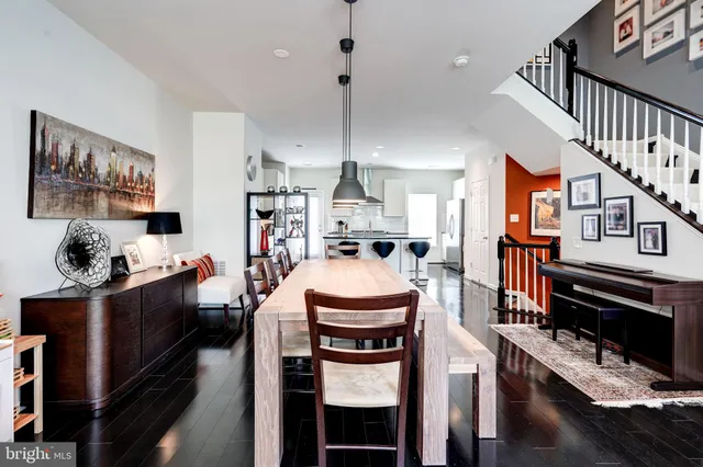 a living room with furniture kitchen view and a chandelier