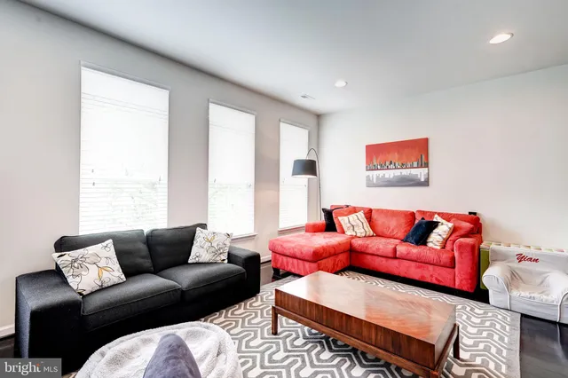 a kitchen with stainless steel appliances granite countertop a stove top oven a sink a dining table and chairs with wooden floor