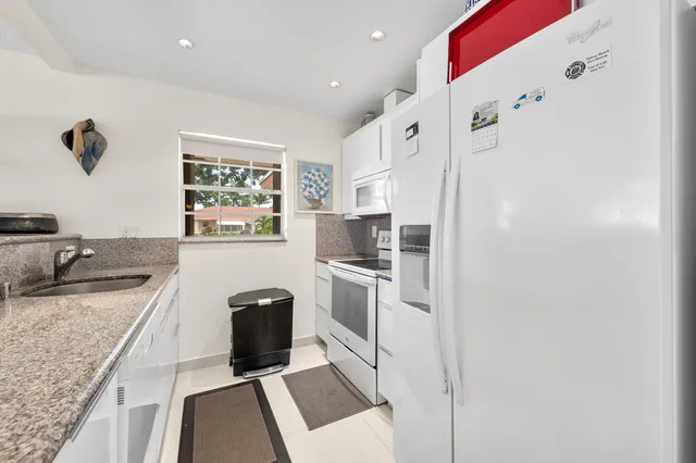 a kitchen with stainless steel appliances granite countertop a refrigerator and a stove