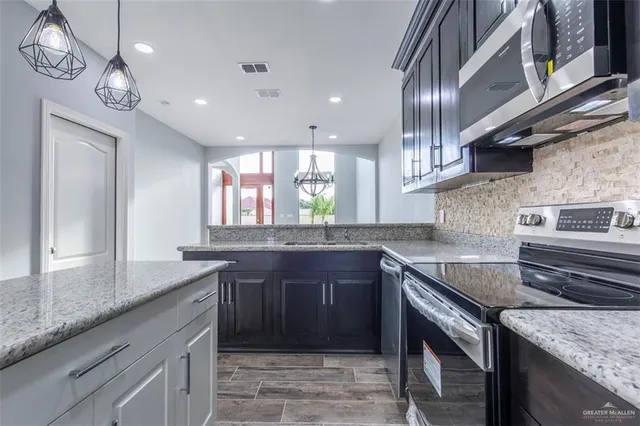 a kitchen with stainless steel appliances granite countertop a sink and stove